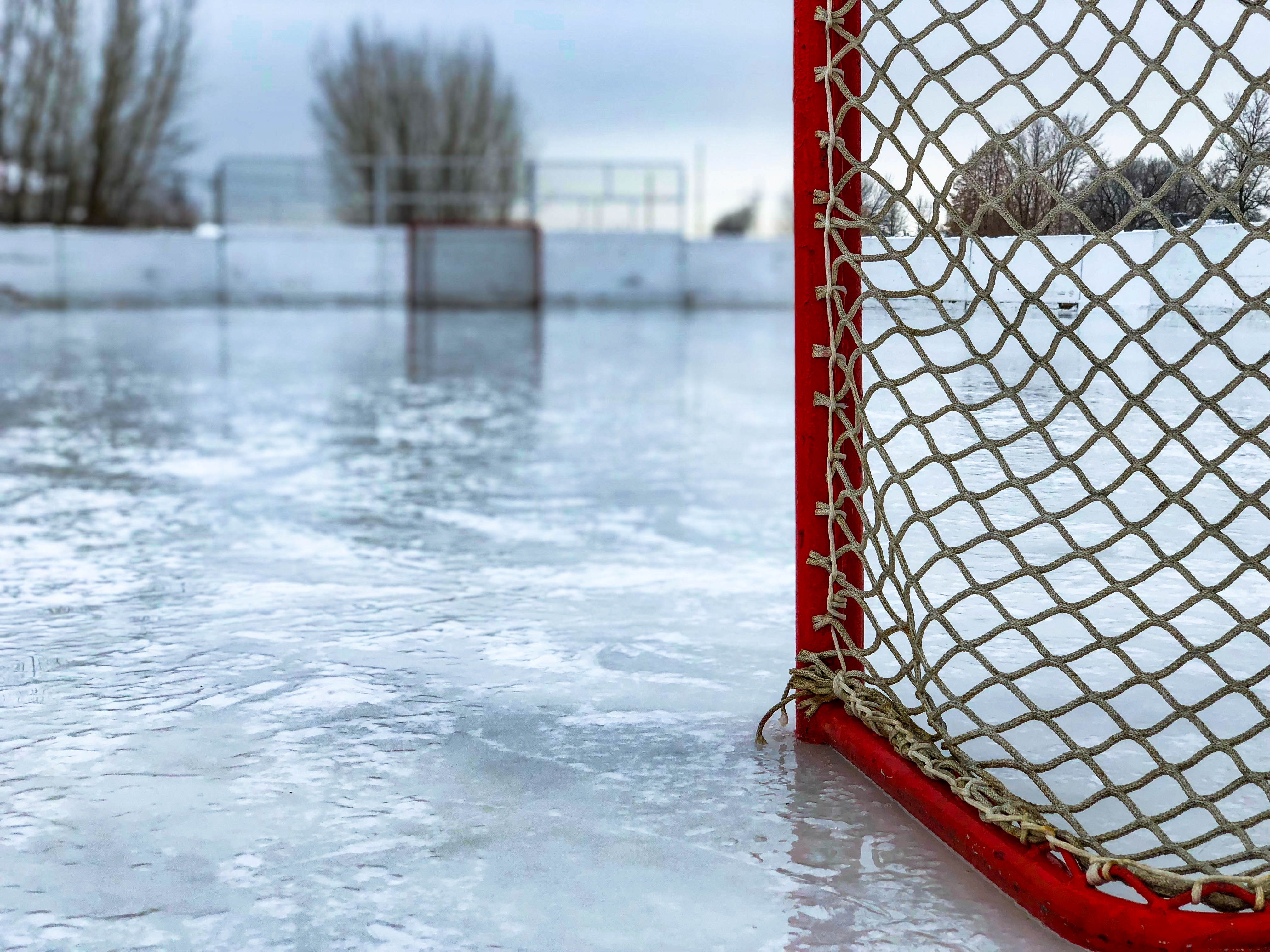 Photograph of a red hockey net on the ice of an outdoor skating rink.