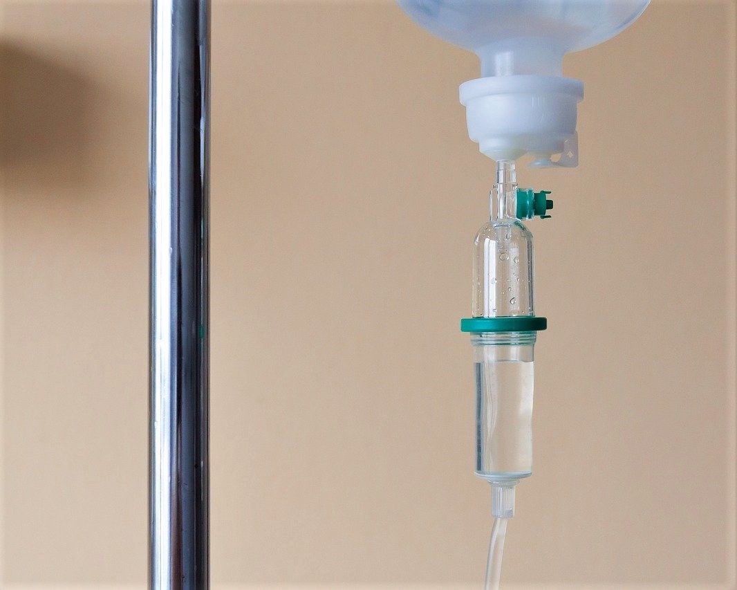 Photograph of an IV drip delivering a pharmaceutical to a patient in a hospital.