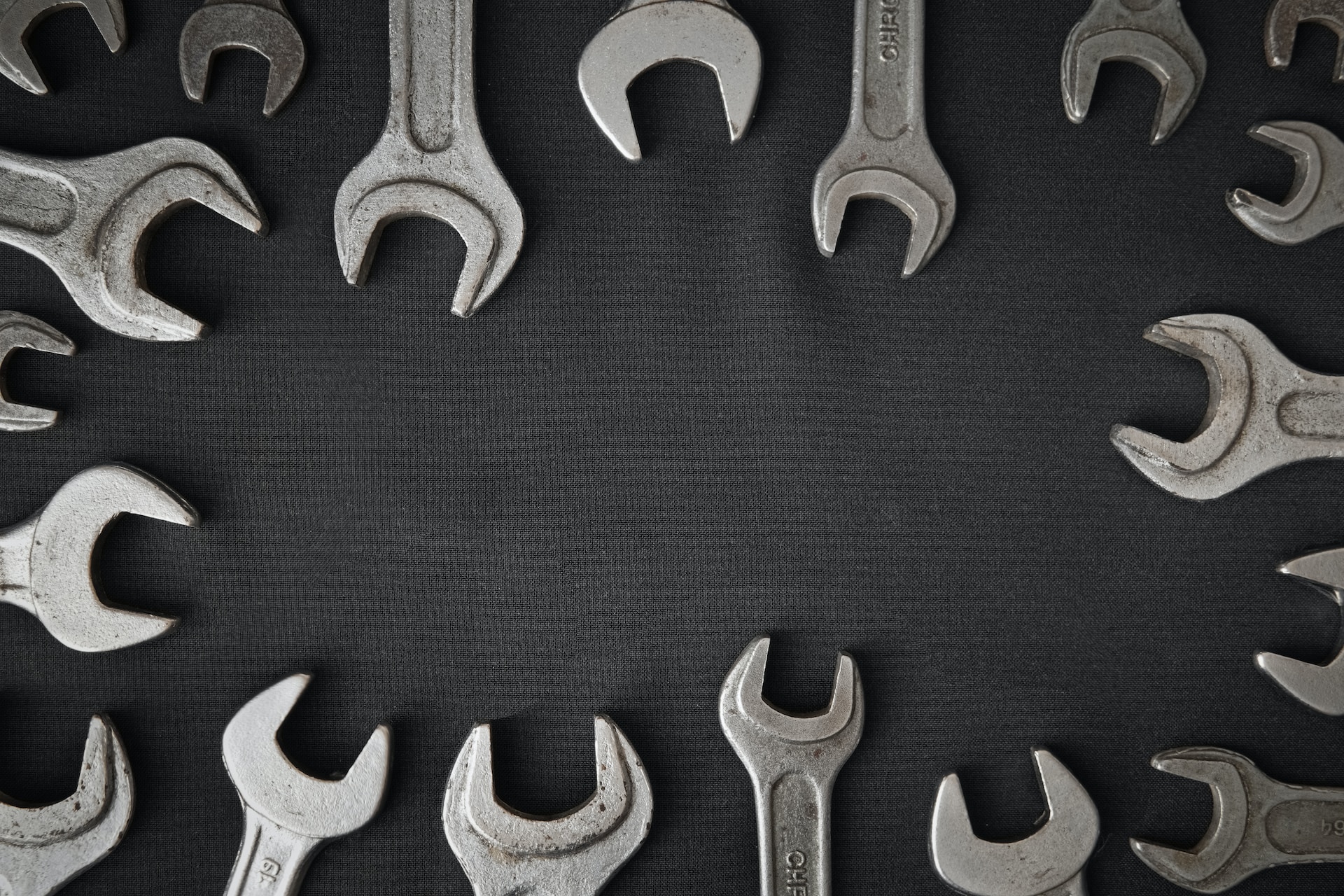 Wrenches on a gray background. The wrenches are arranged around the periphery of the photo.