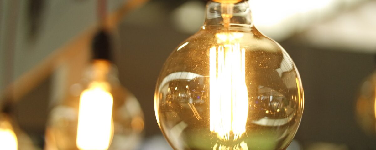 Lightbulbs in a row. Lightbulbs are illuminated, Edison-style glass bulbs.