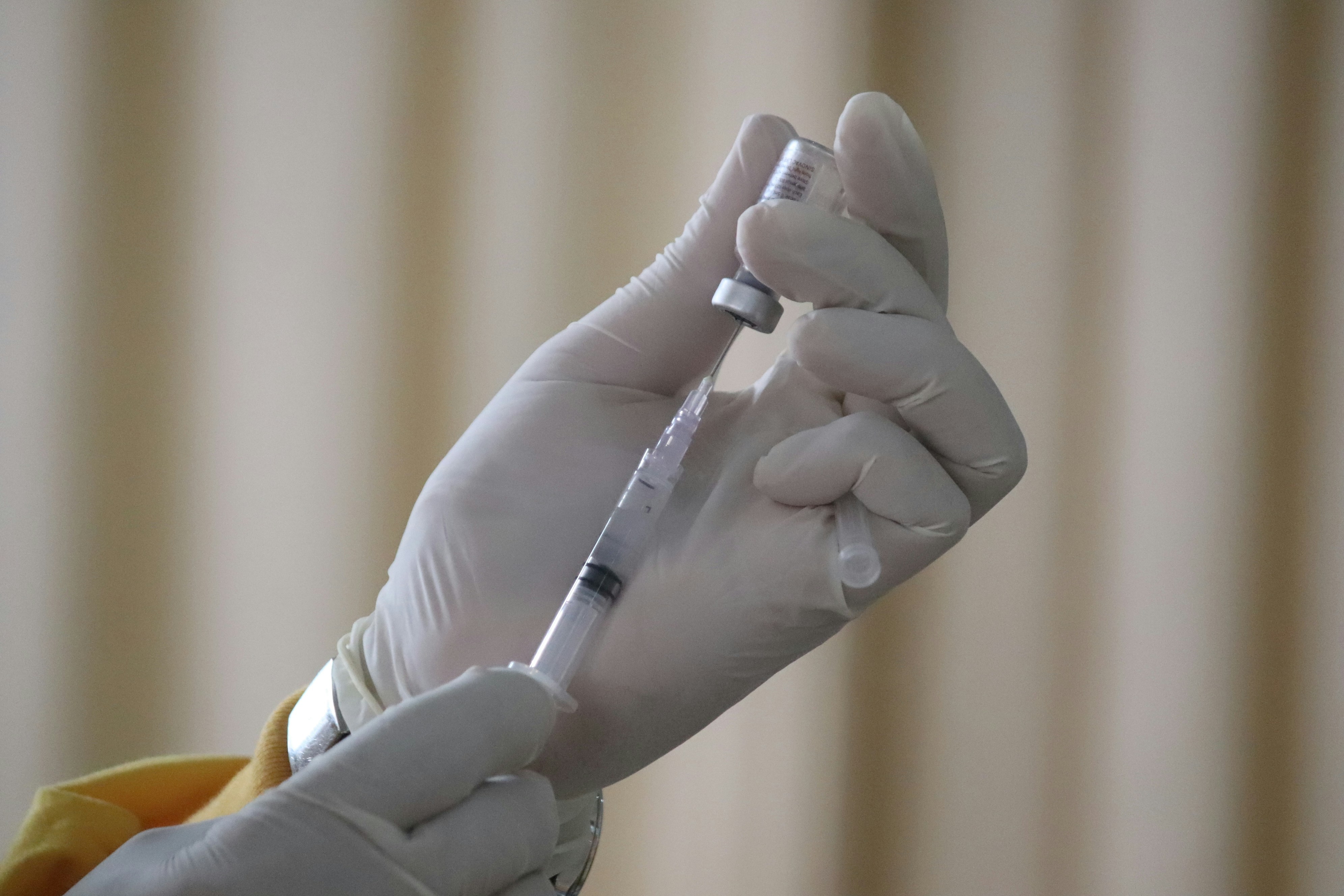 Person holding needle and vial