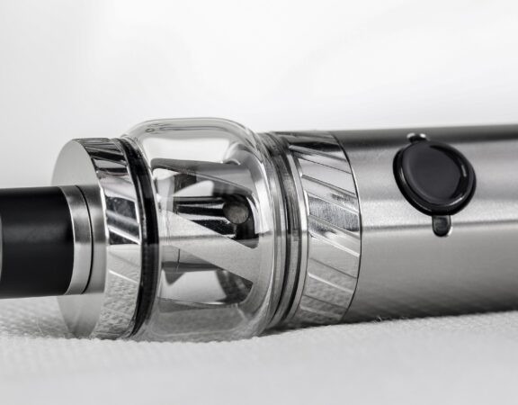 A close-up photograph of a metal vaporizer or vape-pen